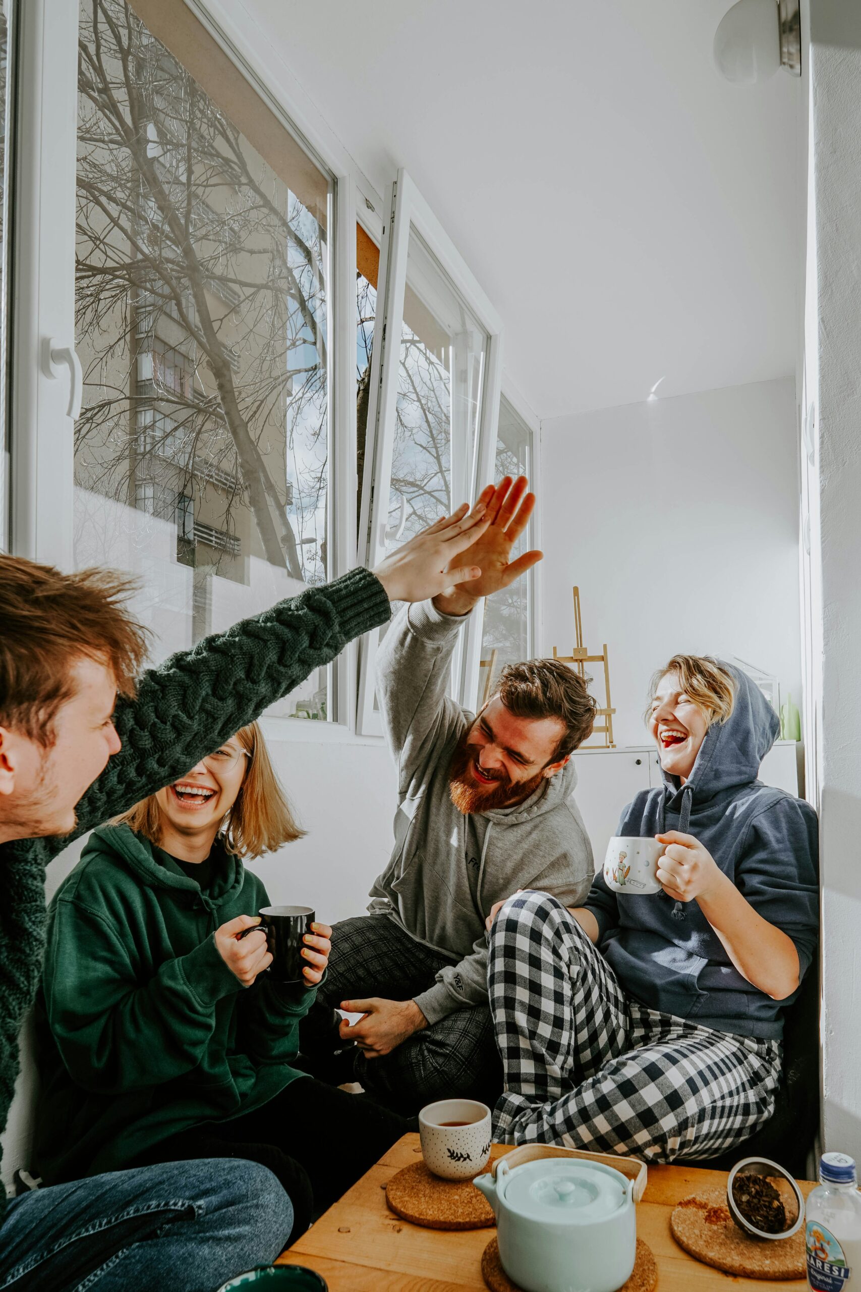 group of friends laughing and hi-fiving