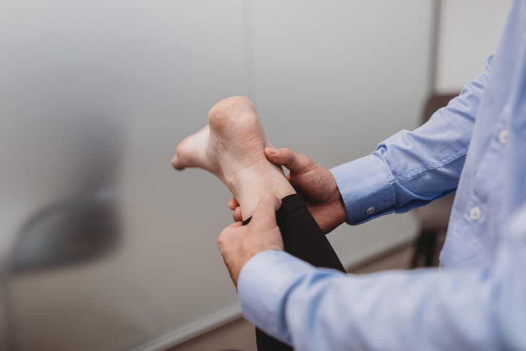 Physio assessing achilles tendon