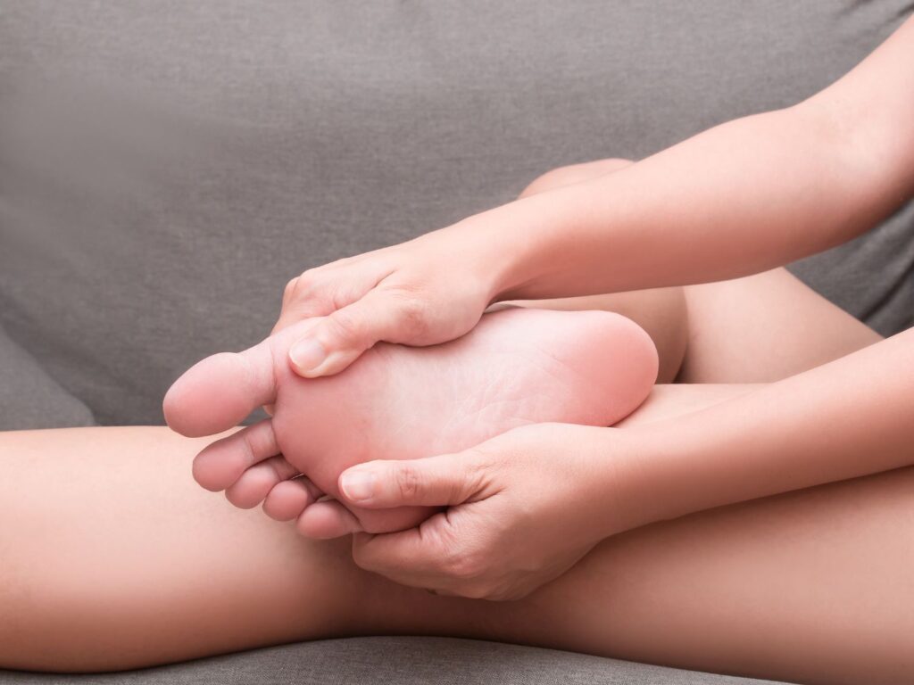 person holding foot with heel pain